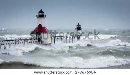 Lake Michigan Lighthouse in St Joe gets pounded during a massive wind storm as huge  waves flow over the entire pier