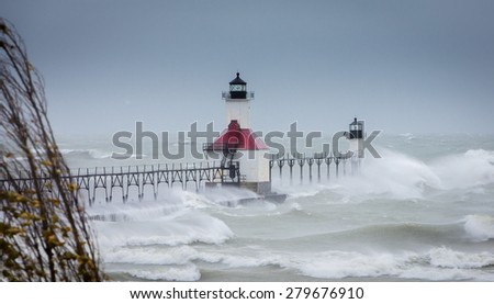 Lake Michigan Lighthouse in St Joe gets pounded during a massive wind storm as huge waves flow over the entire pier