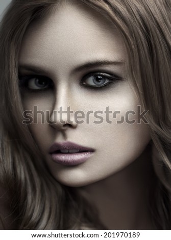 Closeup beauty portrait of young blonde woman with with long straight hair. Professional makeup. Smoky eyes.