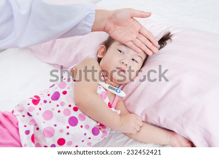 Sick little girl nursed by a pediatrician, doctor touching forehead little asian girl,girl lying with digital mercury thermometer