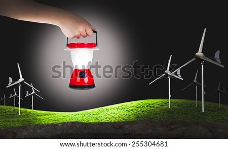 Green earth concept, eco power, wind turbines generating electricity and hand woman holding plastic electric lantern on black background, concepts of searching and direction