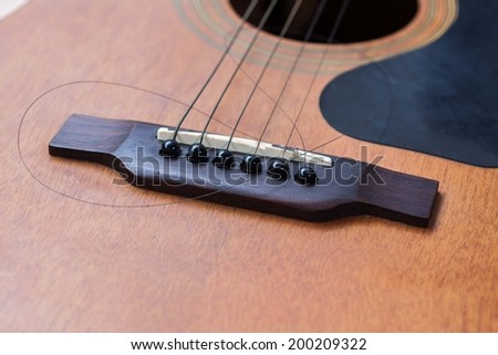 Close up of brown guitar with torn string
