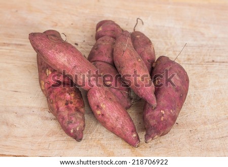 Heap of sweet potato on wooden chopping board