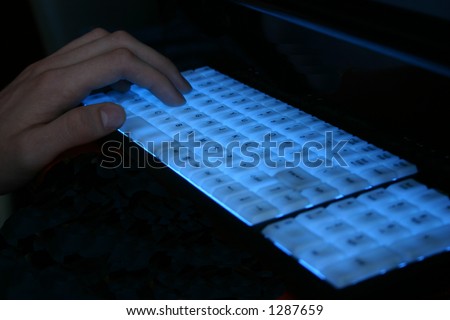 Blue backlit gamer\'s keyboard with  hand
