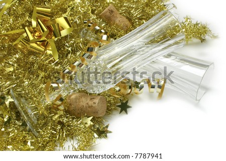 Empty Champagne glasses with corks and tinsel, photographed on white.