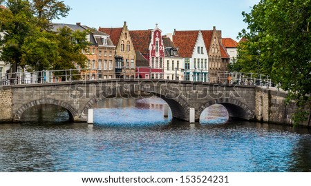 Picturesque view across a bridge to historic brickwall town houses in the famous belgian city of Brugge.
