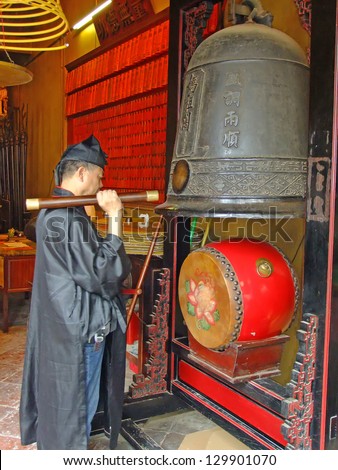 MACAU - SEPTEMBER 19: An unidentified taoist priest hits temple bell during religious ceremony at A-Ma temple on September 19, 2011 in Macau. A-Ma temple is one of the oldest Taoist temples in Macau.