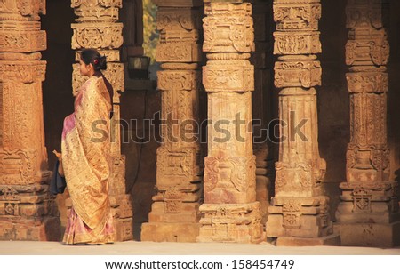 DELHI, INDIA - JANUARY 27: An unidentified woman stands by the columns at Qutub Minar Complex on January 27, 2011 in Delhi, India. Qutub Minar is the tallest minar in India.