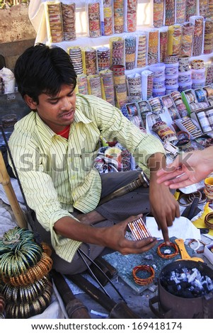 BUNDI, INDIA-FEBRUARY 4: An unidentified man fixes bracelets at market on February 4, 2011 in Bundi, India. Bundi is a popular place of attraction and tourism industry primarily supports its economy