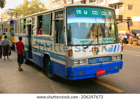 YANGON, MYANMAR - JANUARY 11: Unidentified people get on a local bus on January 11, 2012 in Yangon, Myanmar. Yangon is the largest city and the most important commercial centre in Myanmar.
