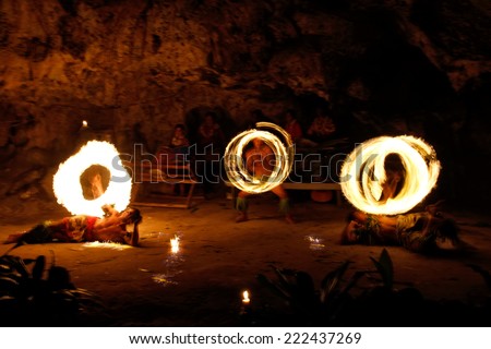 TONGATAPU, TONGA - NOVEMBER 13: Unidentified men perform fire dance (blurred motion) in Hina cave on November 13, 2013 in Tongtapu, Tonga. Famous Hina cave is a big tourist attraction on Tongatapu.