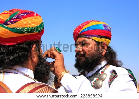 JAISALMER, INDIA - FEBRUARY 16: Unidentified men help each other at Desert Festival on February 16, 2011 in Jaisalmer, India. Main purpose of this Festival is to display colorful culture of Rajasthan