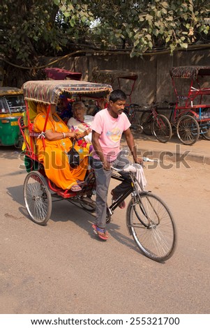 DELHI, INDIA - NOVEMBER 5: Unidentified people ride cycle rickshaw on November 5, 2014 in Delhi, India. Cycle rickshaw is popular mode of travel for short distance transits in the city.
