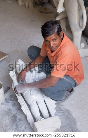 DELHI, INDIA - NOVEMBER 5: Unidentified man works  on a statue at a workshop on November 5, 2014 in Delhi, India. Delhi is the second most populous city in India.
