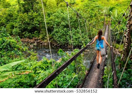Young woman walking on suspension bridge over Wainibau stream, Lavena Coastal Walk, Taveuni Island, Fiji. Taveuni is the third largest island in Fiji. Zdjęcia stock © 