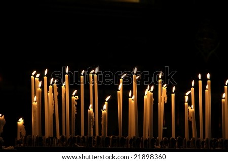Burning candles in cathedral Duomo in Milan