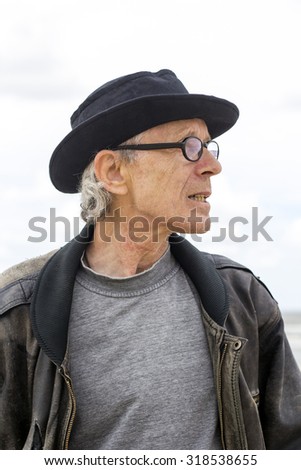 Older Man with Hat and Glasses Wearing a Leather Jacket
