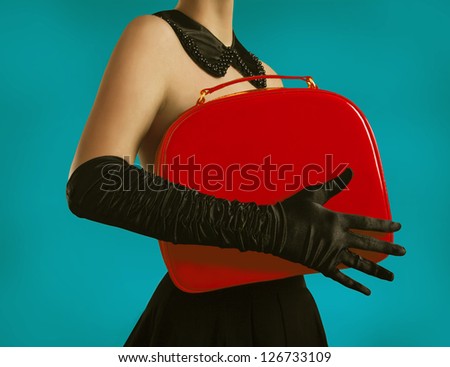 Elegant lady in gloves holding a red bag