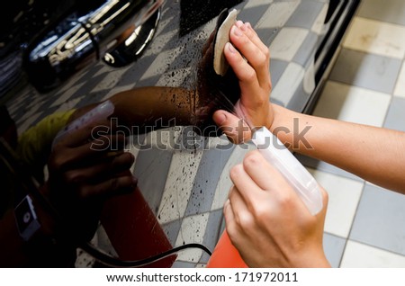 Hand polishing by clay bar and clay  lubricant for remove dirt on car surface in car-wash shop