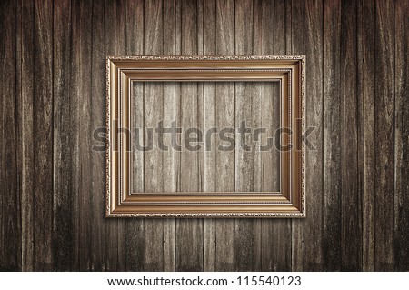 Golden picture frame on wood background