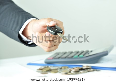 Businessman hand giving a car key - car rent, sale & pawn concept