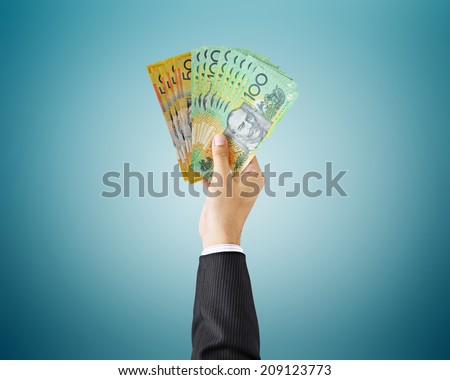 Hand holding money - Australian dollar (AUD) bills