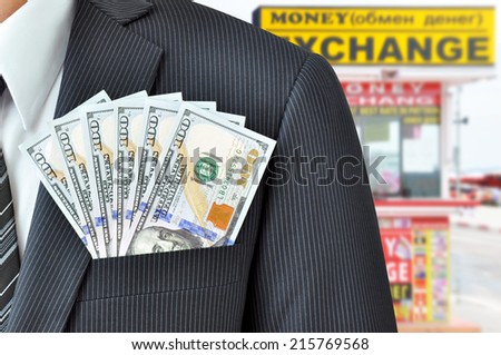 Money (US dollar bills) in businessman pocket - money exchange concept