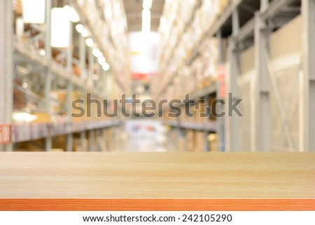 Empty wood table top or shelf on blurred warehouse background