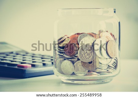 Coins in the glass jar, mixed Asian multi currencies - vintage (retro) color effect