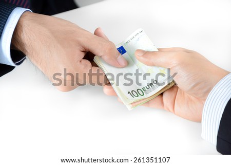 Businessman hands giving & receiving money, Euro currency (EUR) - bribery concept