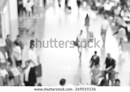 Blurred people at the airport hallway in black and white, can be used as background