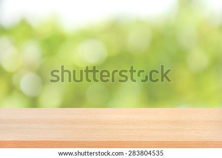 Wood table top on green bokeh abstract background, soft tone - can be used for montage or display your products