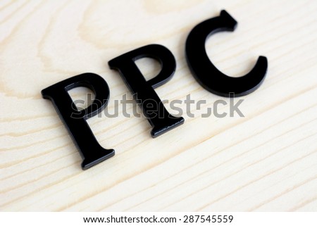 PPC or Pay Per Click sign on wood background, internet (online) marketing and advertising concepts