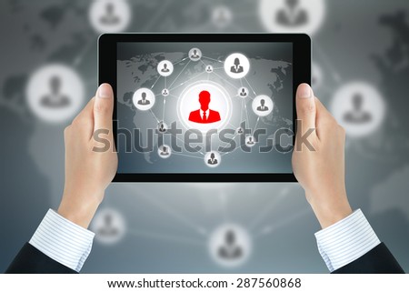 Businessman hands holding tablet pc with businesspeople icons linked as network on the screen - online business & social network concepts