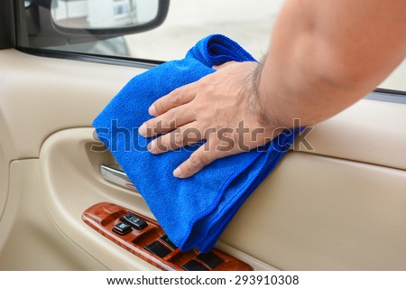 Hand cleaning interior car door panel with microfiber cloth