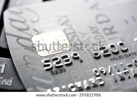 Close up of credit card with chip and numbers, gray and silver theme