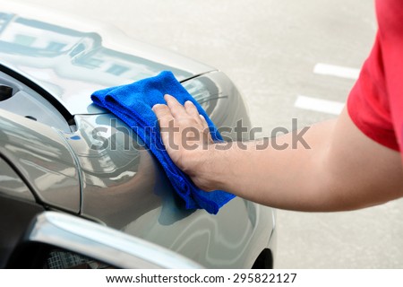 Hand rubbing and polishing car with microfiber cloth