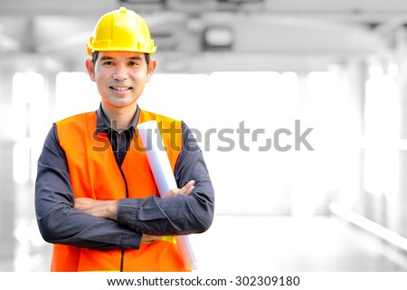 Asian architect or engineer wearing safety vest and hard hat (or helmet)