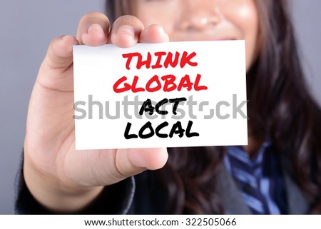 THINK GLOBAL ACT LOCAL message on the card shown by a businesswoman