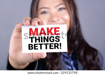 MAKE THINGS BETTER! message on the card shown by a businesswoman
