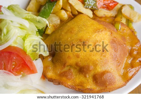 Meat pie with salad , fries and peppers