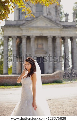 beautiful  bride  stands next to old church