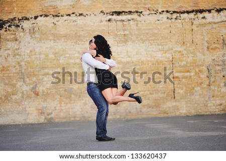 Romantic young couple having a great time next to the wall of breaks