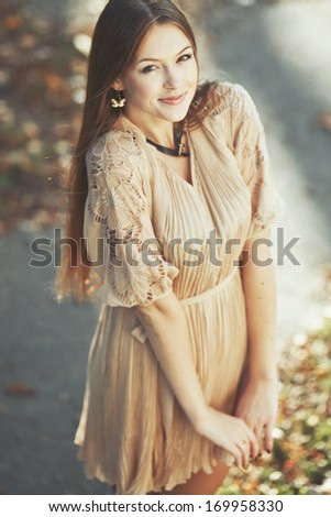 Natural portrait of young beautiful woman outside. Caucasian woman with long hair wearing dress on sunny summer day.
