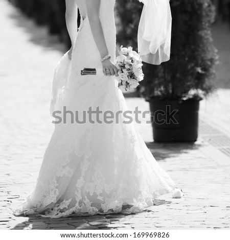 Stylish bride walking street, wedding fashion, black and white.