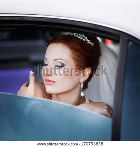 Portrait of beautiful bride. Happy lovely red hair young bride in limo.
