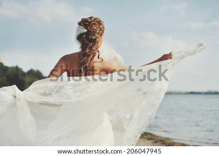 Gorgeous caucasian bride playing with veil, spinning around. Happy wedding day.