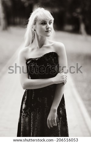 Black and white portrait of a blond woman in black dress . Summer girl.