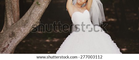 Happy bride posing in forest. Summer wedding picture.