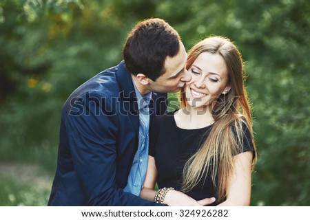 Young couple posing in garden. Boyfriend and girlfriend together.